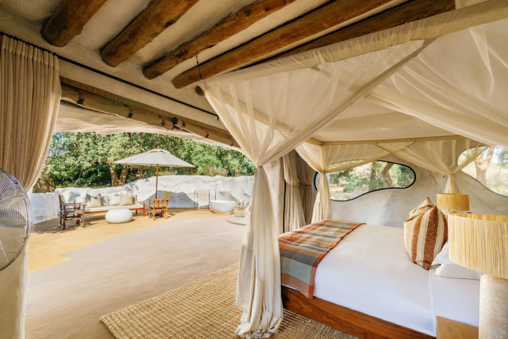 A bedroom opens onto a private terrace with a free-standing bathtub, lounge seating and river views.
