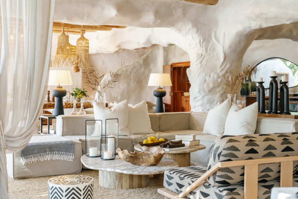 A sculptural lounge area with curved plaster archways, plush sofas and warm, textured decor.