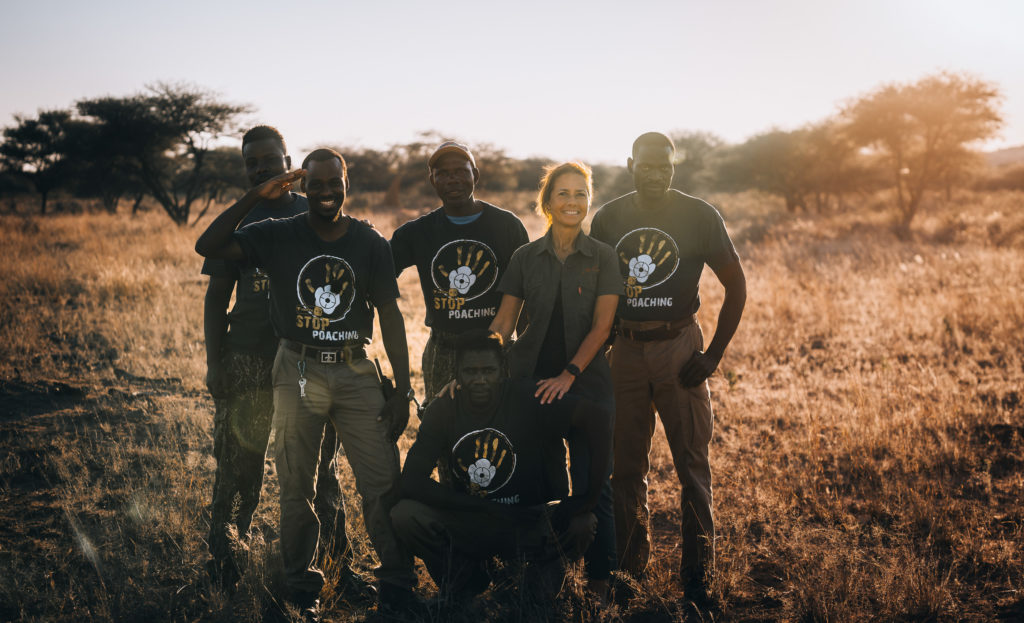 AfriCat anti-poaching team members gathered in the golden light of the reserve