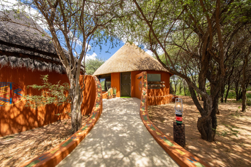 Pathway leading to a thatched chalet at Okonjima Luxury Bush Camp