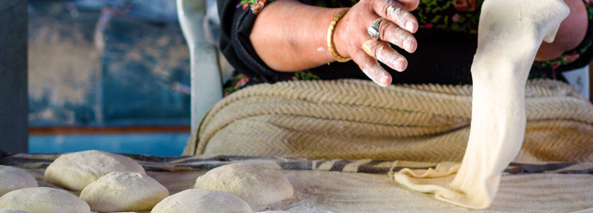 Old Arab women kneading fresh dough