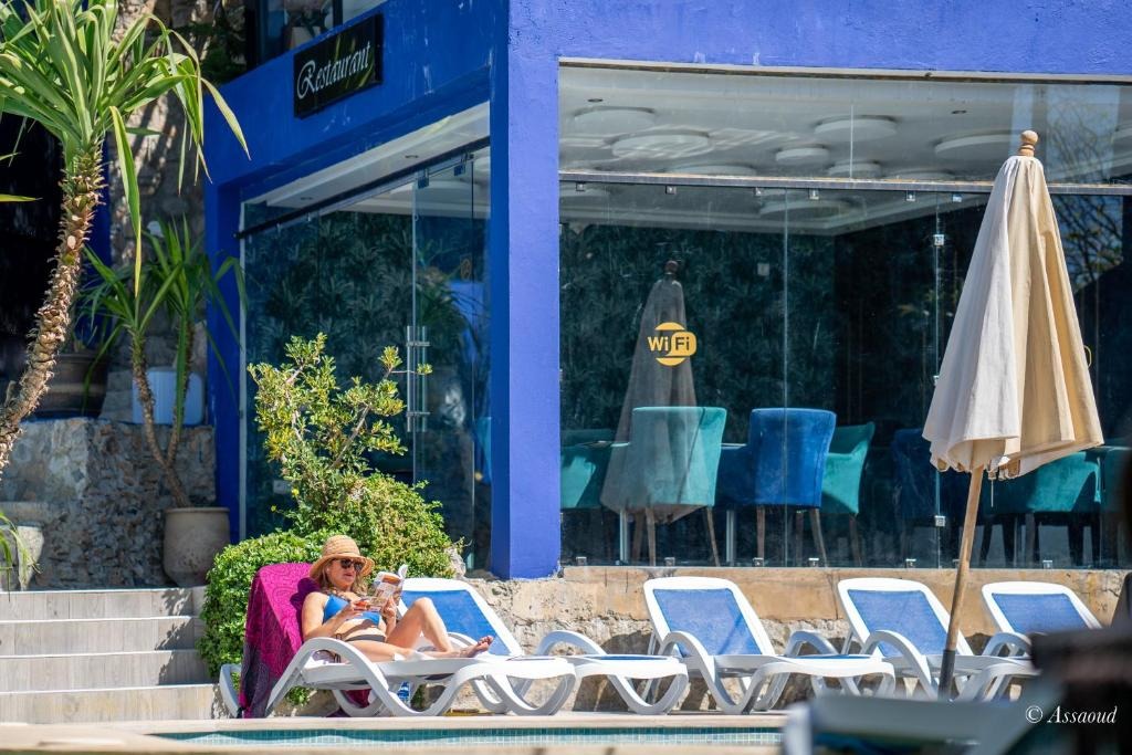 Poolside view of the Ziryab restaurant with sun loungers and a Wi-Fi sign in the window