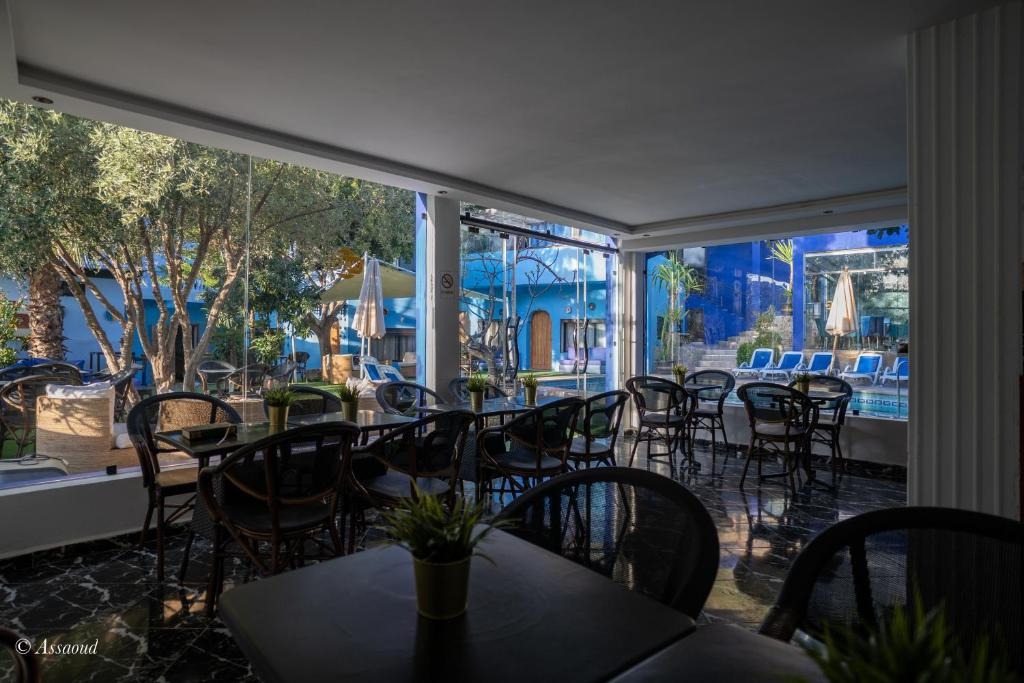 Terrace dining area open to the garden and pool, with Chefchaouen's blue buildings visible beyond