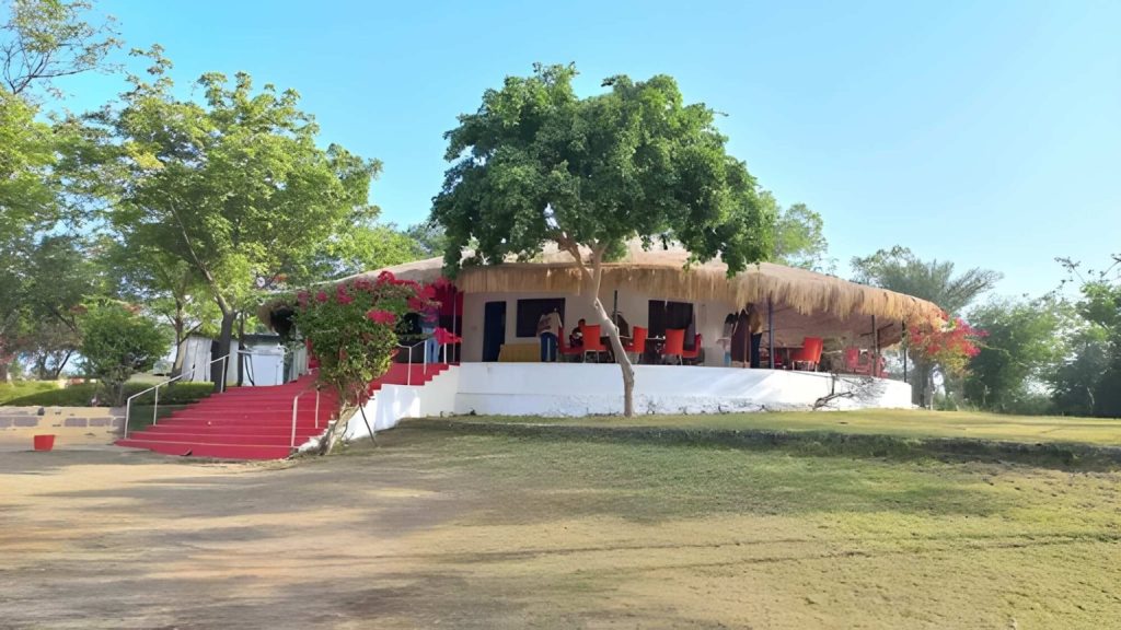 Thatched restaurant terrace with red steps and bougainvillea, Kutch Safari Resort