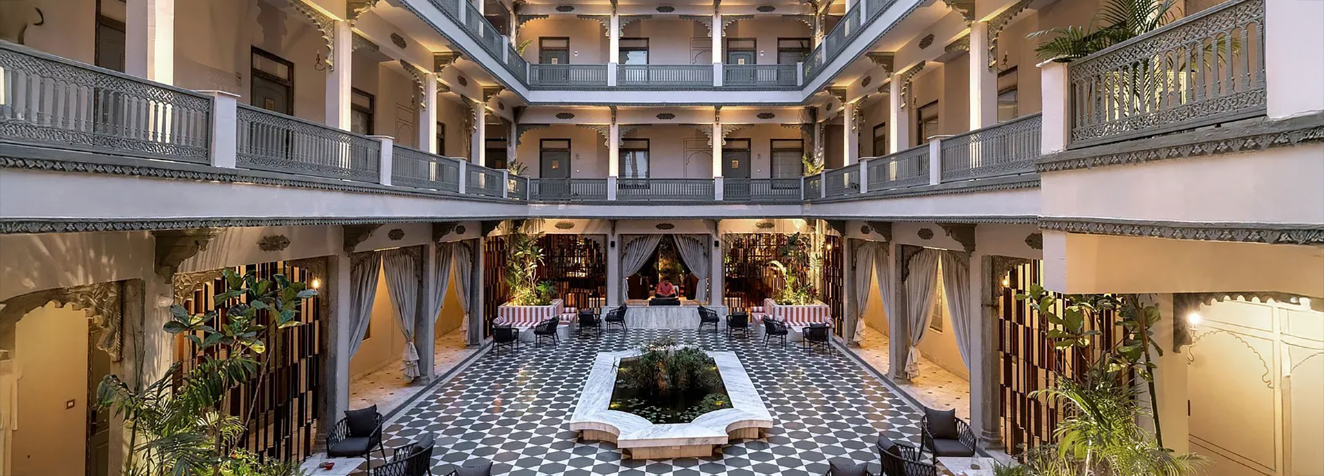 Grand heritage-style courtyard with checkered floor tiles and striped seating