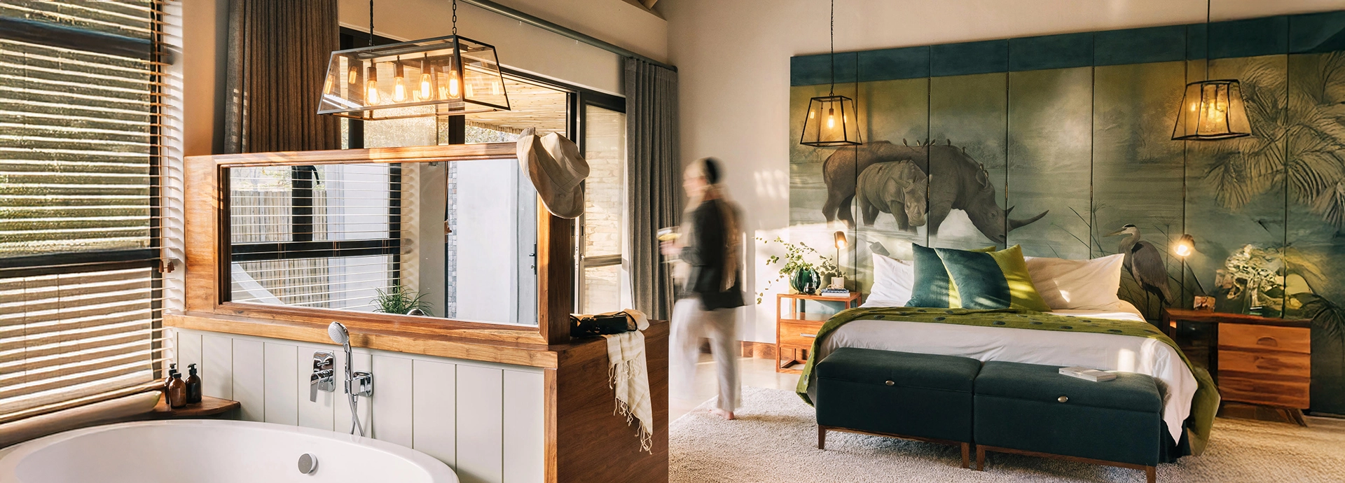 An elegant en suite bedroom at Simbavati Camp George featuring classic safari design, warm textures, and views into the bush.