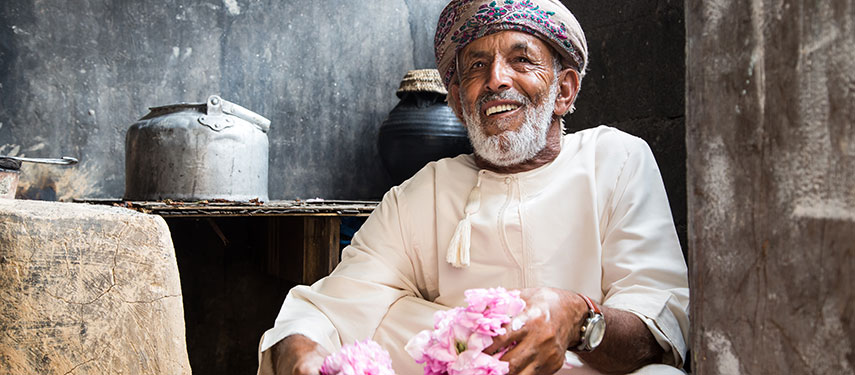 Oman man with a basket of pink bougainvillea flowers