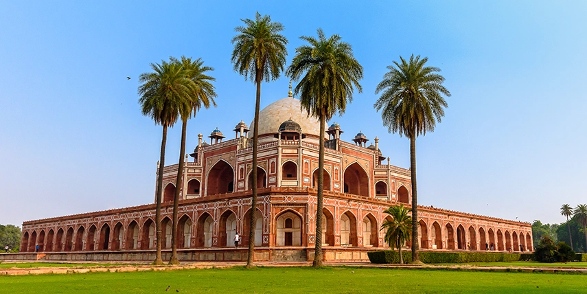 Humayun’s Tomb in Delhi framed by palm trees and manicured gardens, an early Mughal masterpiece that inspired the design of the Taj Mahal. 