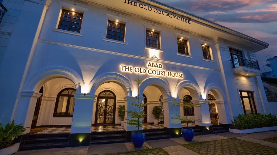 The Old Court House facade illuminated at dusk, its arched colonnade glowing warmly against the evening sky.
