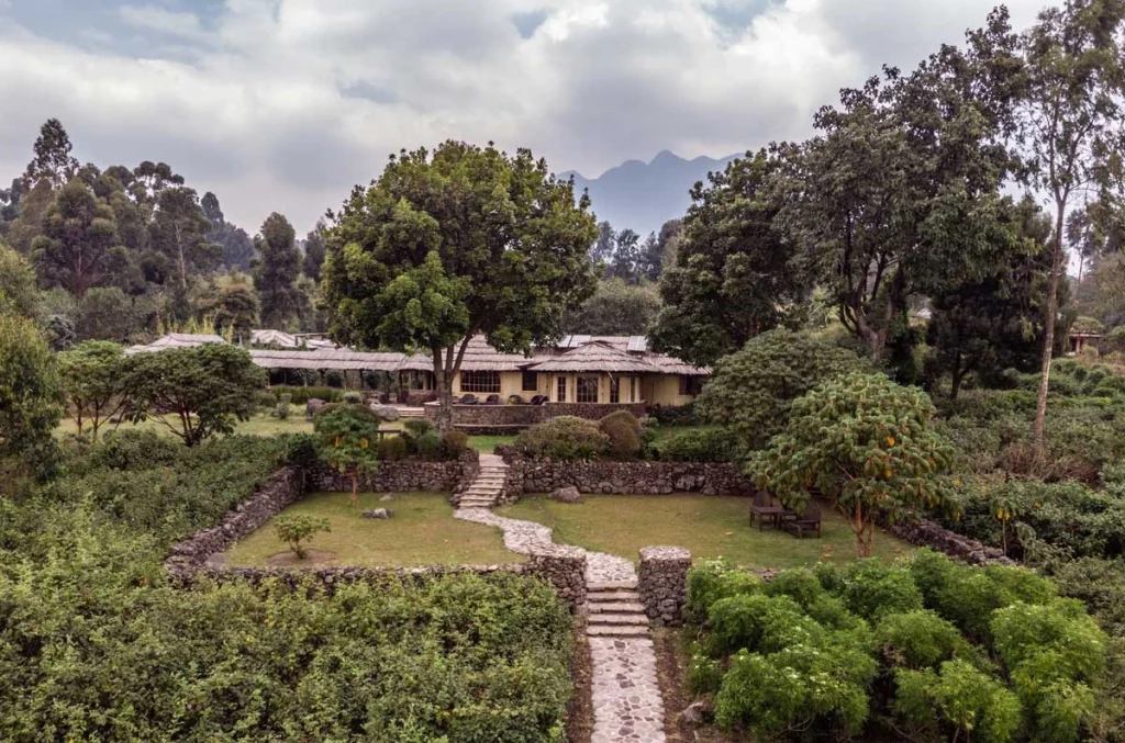 Mount Gahinga Lodge with stone pathways and thatched bandas at the foot of the Virunga Volcanoes, Uganda