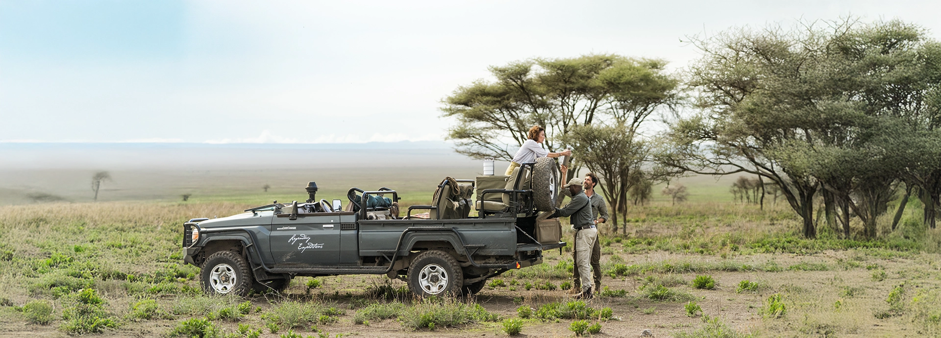 A guided safari vehicle pauses on the plains for a relaxed picnic lunch, capturing the freedom and scale of game drives around Nyasi Tented Camp.