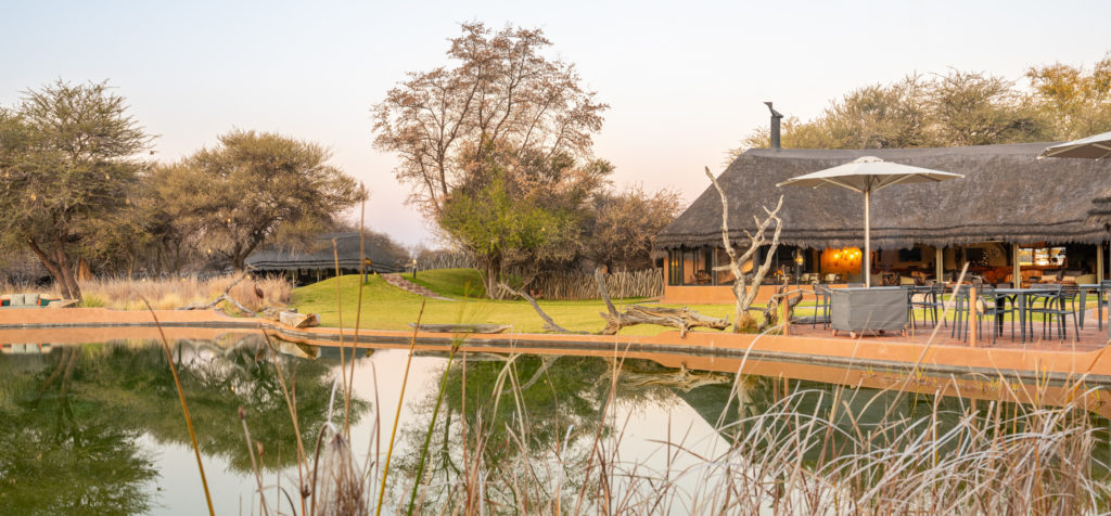 Okonjima Luxury Bush Camp at dusk with the lapa reflected in the waterhole