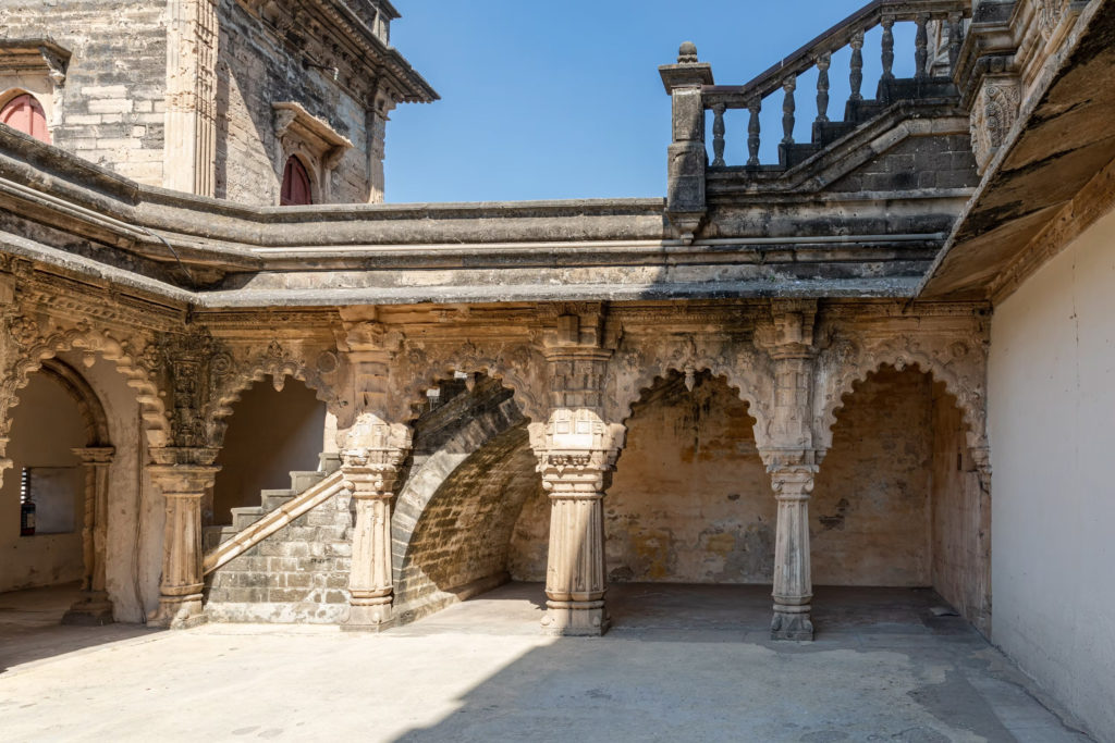 A weathered stone stairway and scalloped arches inside the historic Gondal palace complex