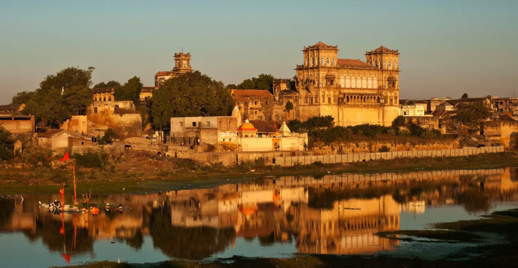 The turreted skyline of Gondal's royal palace complex reflected in the river at golden hour