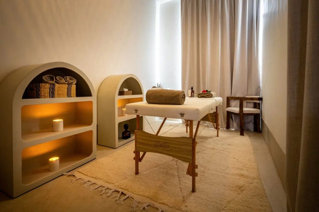 Spa treatment room with candlelit arched shelving & a personalised massage table