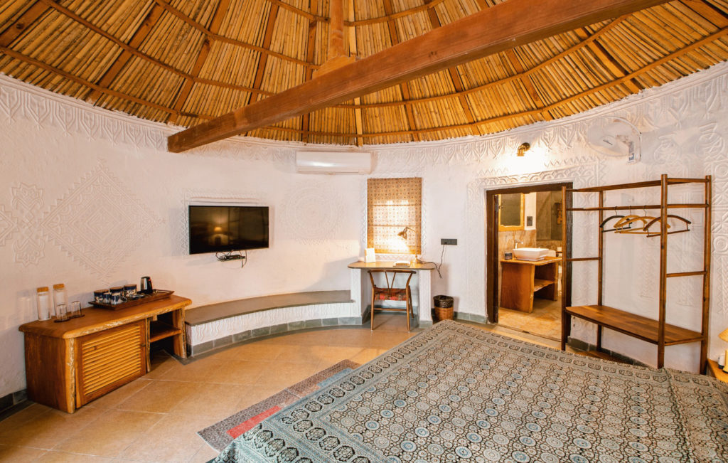 Round Kooba cottage bedroom with a domed bamboo ceiling and hand-textured white plasterwork walls.