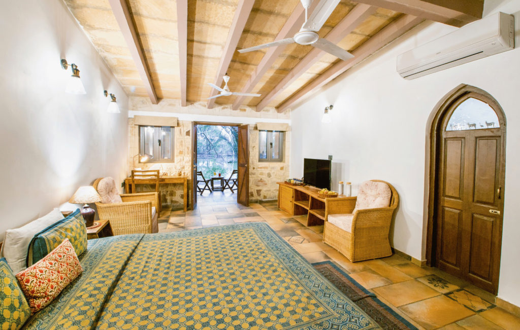 Lake-facing Dasada Premium Wing bedroom with vaulted stone ceiling and a private terrace overlooking the water.