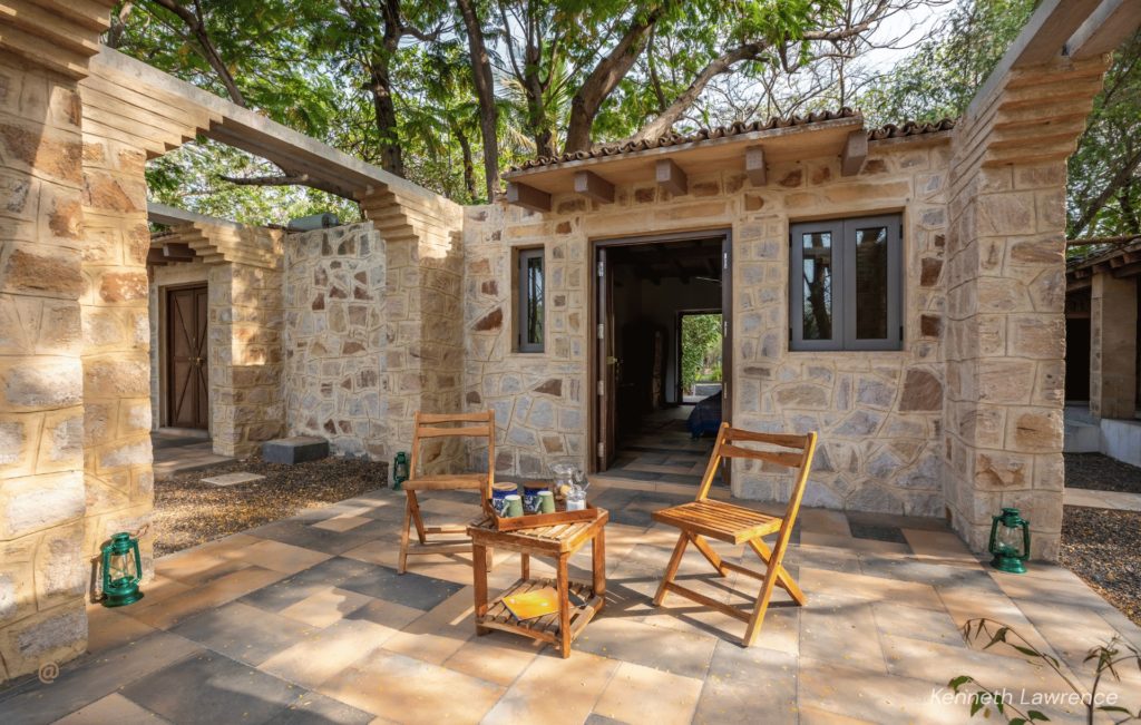 Stone cottage courtyard with wooden chairs at Rann Riders Resort