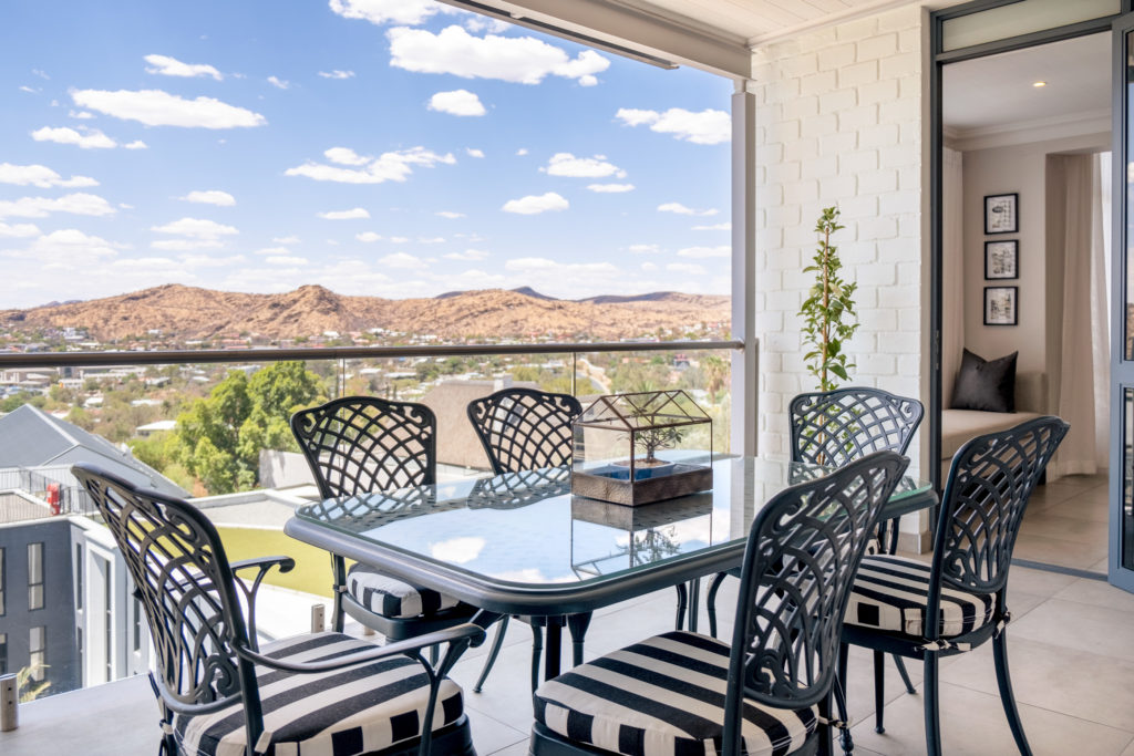 Terrace Suite balcony at The Weinberg with dining table set for six overlooking the Windhoek hills