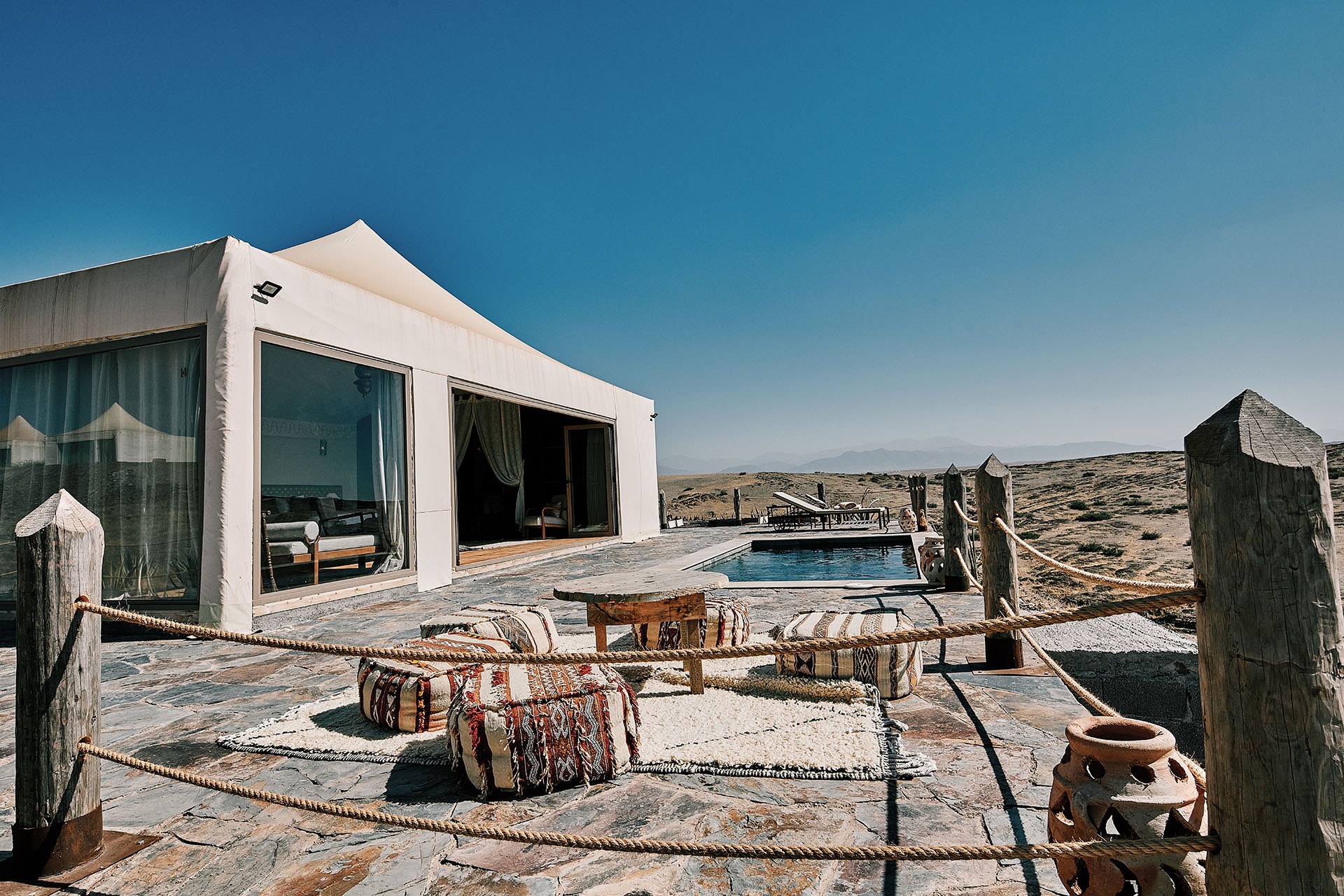 A canvas lodge with private pool and terrace, roped walkway leading through the surrounding Agafay hills.