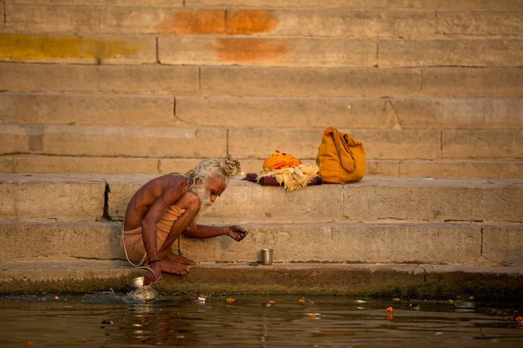 Sadhu makes offering in the Ganges on the ghats of Varanasi