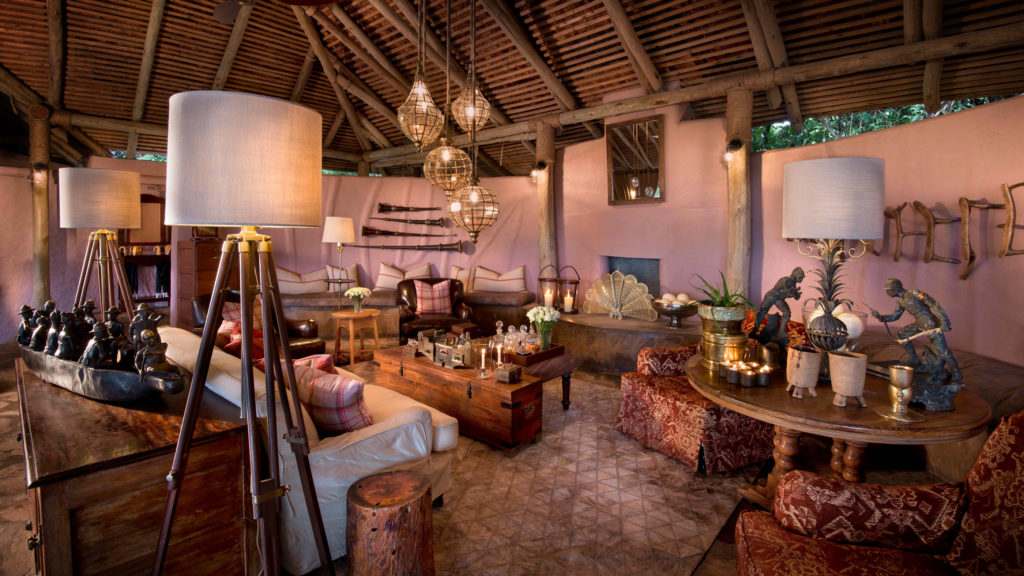 A thatched lounge filled with antique lamps, leather armchairs and vintage safari memorabilia