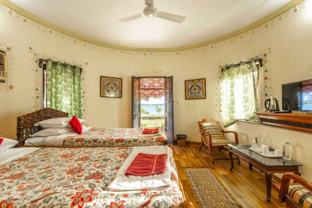 Cottage interior with twin beds and doors opening onto the lake