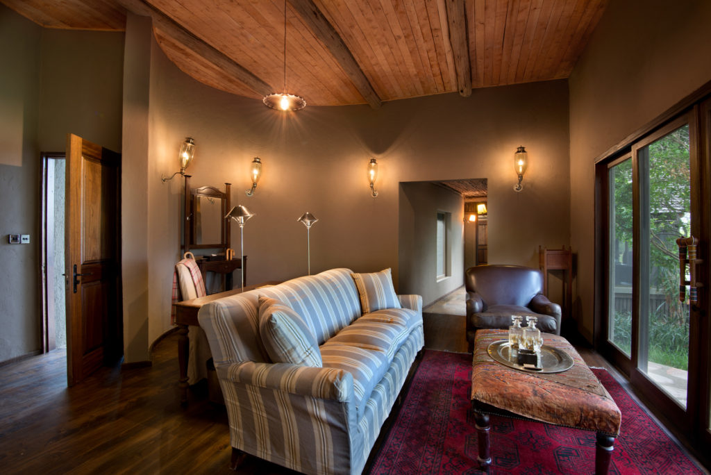 A striped sofa and leather armchair furnish the interior passage linking the two rooms of a Luxury Family Tent