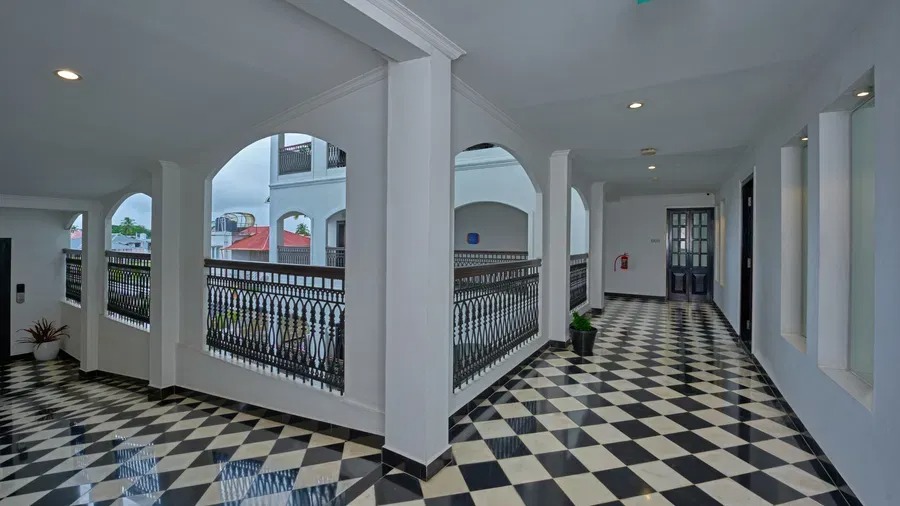 White archways and columns line a checkered corridor at The Old Court House, framing views of the property's inner courtyard.