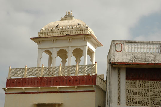 A domed rooftop cupola with scalloped arches and a red-trimmed balustrade crowns Darbargadh Poshina
