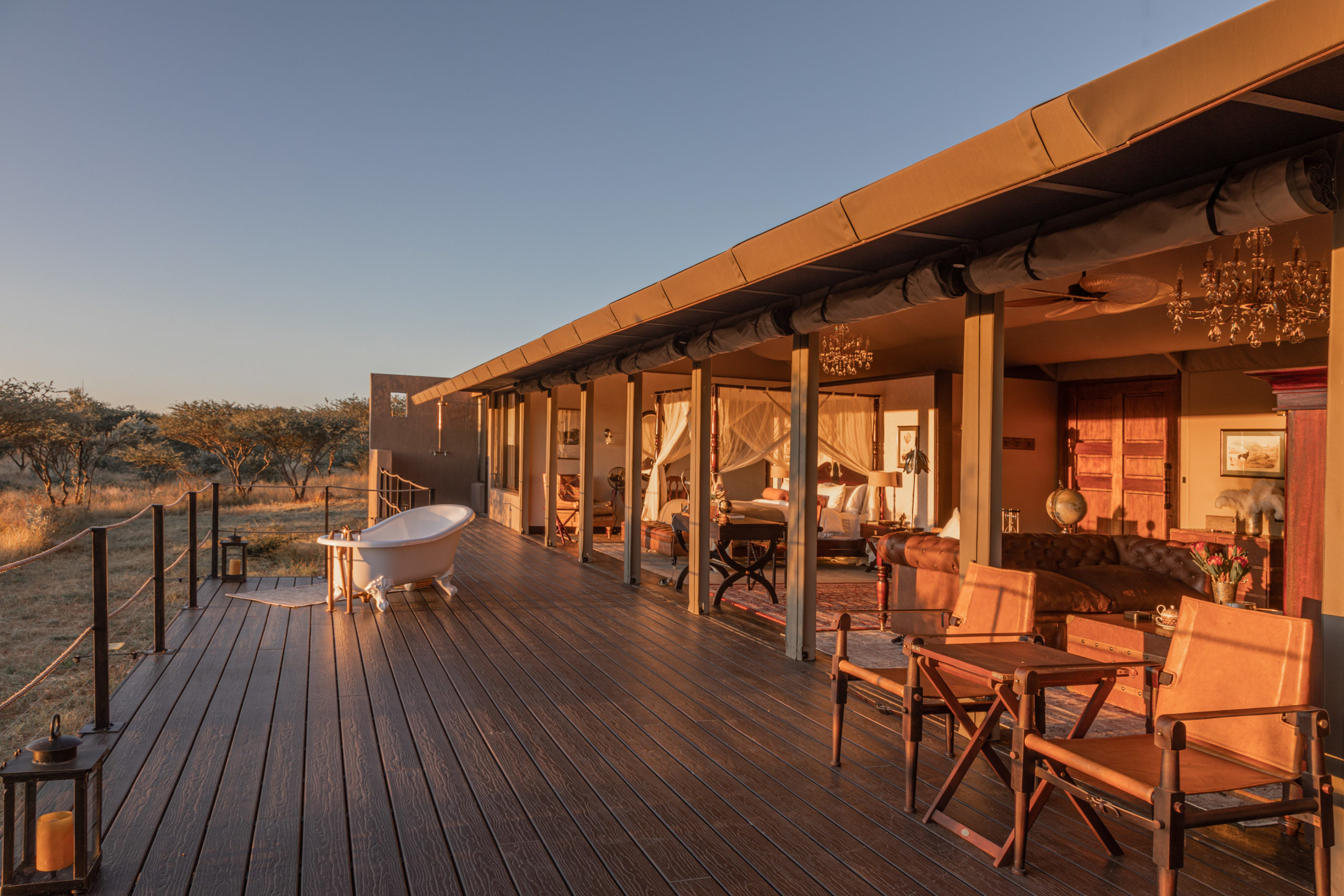 A freestanding bathtub sits on the suite's outdoor deck, with the bedroom visible beyond