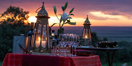 Romantic lamp-lit dinner setup at sunset in Kenya